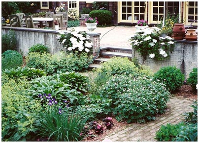Layered perennial beds along a brick path and stone patio, from M&A's design pages